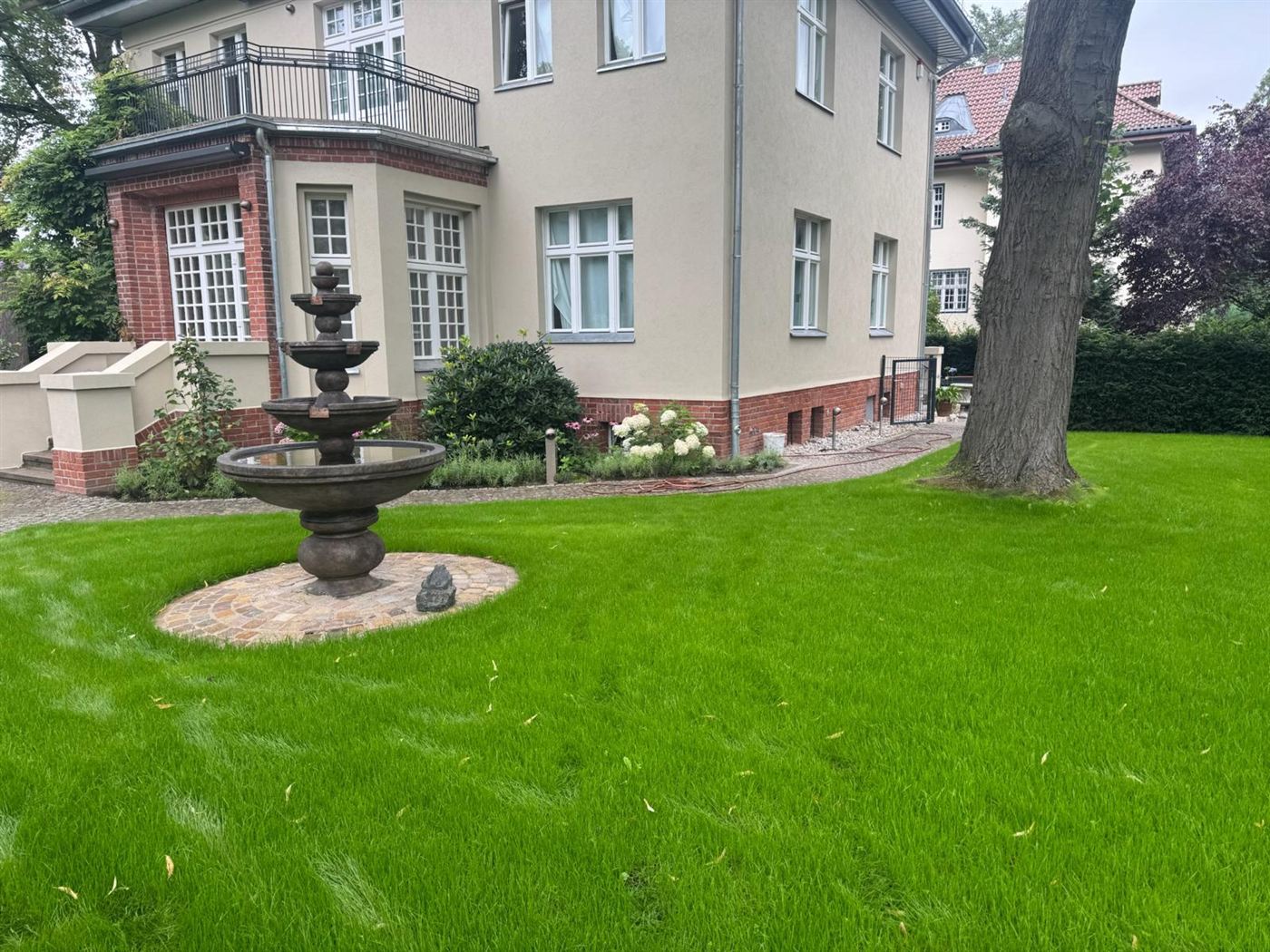 Neu angelegter Rasen mit Brunnen vor einer sanierten Villa in Berlin-Dahlem